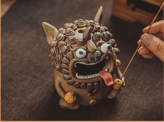 This is a pottery teapet incense holder